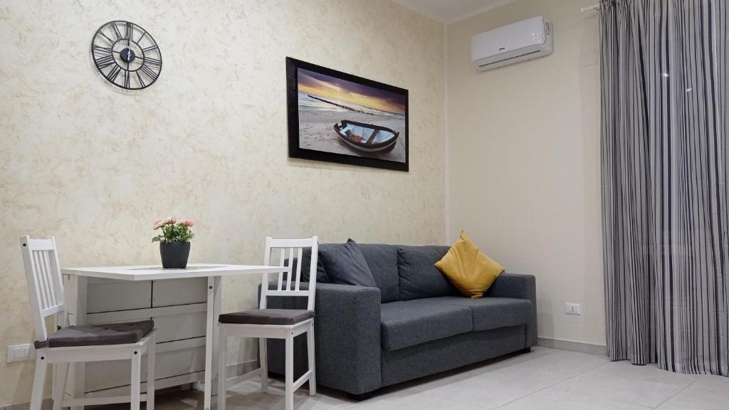 uma sala de estar com um sofá e uma mesa em Casetta Delia em Palermo