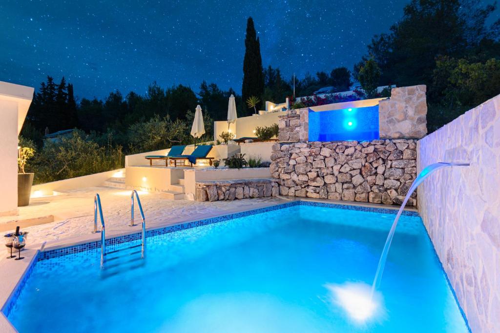 una piscina in un cortile posteriore di notte di Holiday Home Likva - Sutivan - Island of Brač a Sutivan (San Giovanni di Brazza)