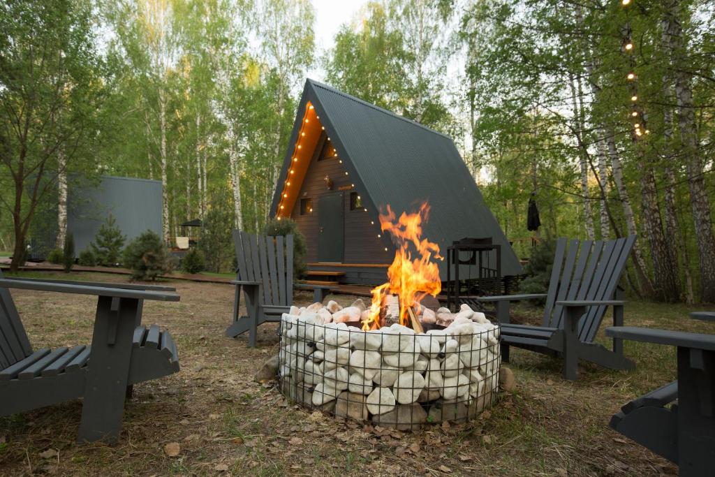 a fire pit in front of a cabin at Kedr Camp - лесной детокс, 40 км от Уфы 