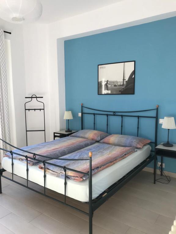 um quarto com uma cama com uma parede azul em Casa Madama em Cannero Riviera