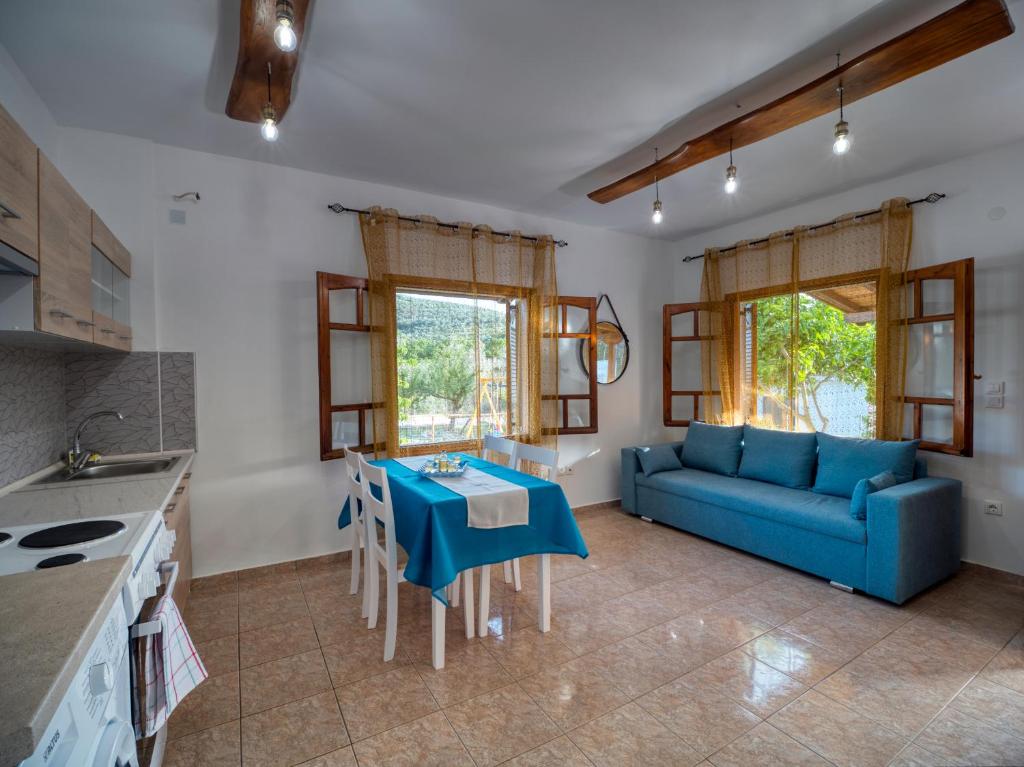 a living room with a blue couch and a table at Σπιτι στην εξοχη - Country House Milina in Milína