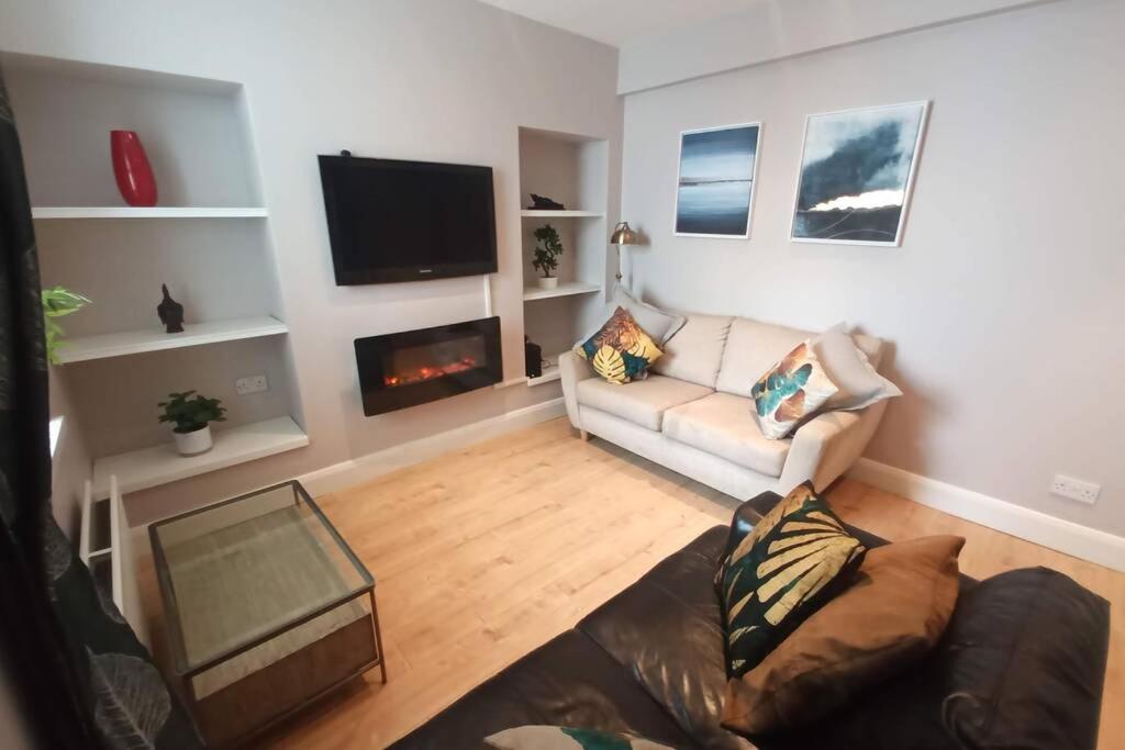 a living room with a couch and a fireplace at Argyle House, 10 minute walk from city centre in Derry Londonderry