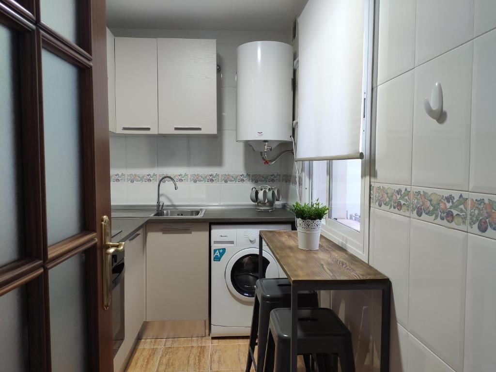 małą kuchnię z pralką i stołem w obiekcie Apartamento Amplio, Séneca 3B junto al Centro w Maladze