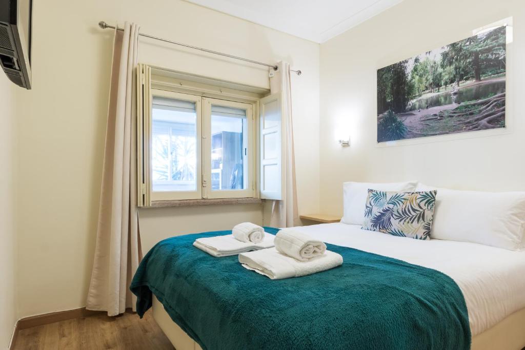 a bedroom with a bed with towels on it at Vita Portucale ! 3 Bedroom Apartment with Private Terrace in Lisbon