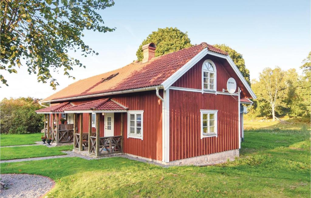 una casa roja con techo rojo en un campo verde en Hultets gård, en Lerdala