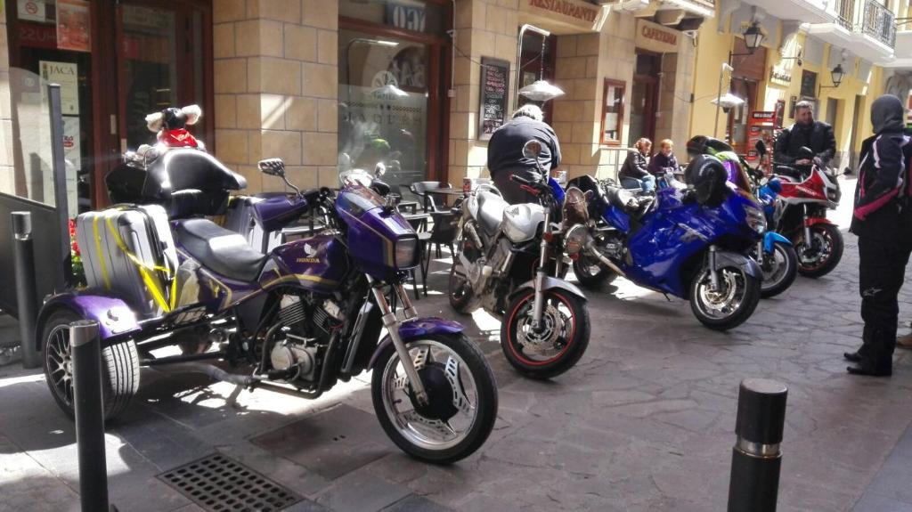 a row of motorcycles parked on a city street at Hotel Jaqués in Jaca