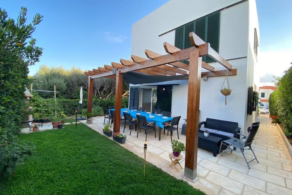 a patio with a table and chairs under a pergola at Villa Blanca Punta Grossa in Punta Grossa