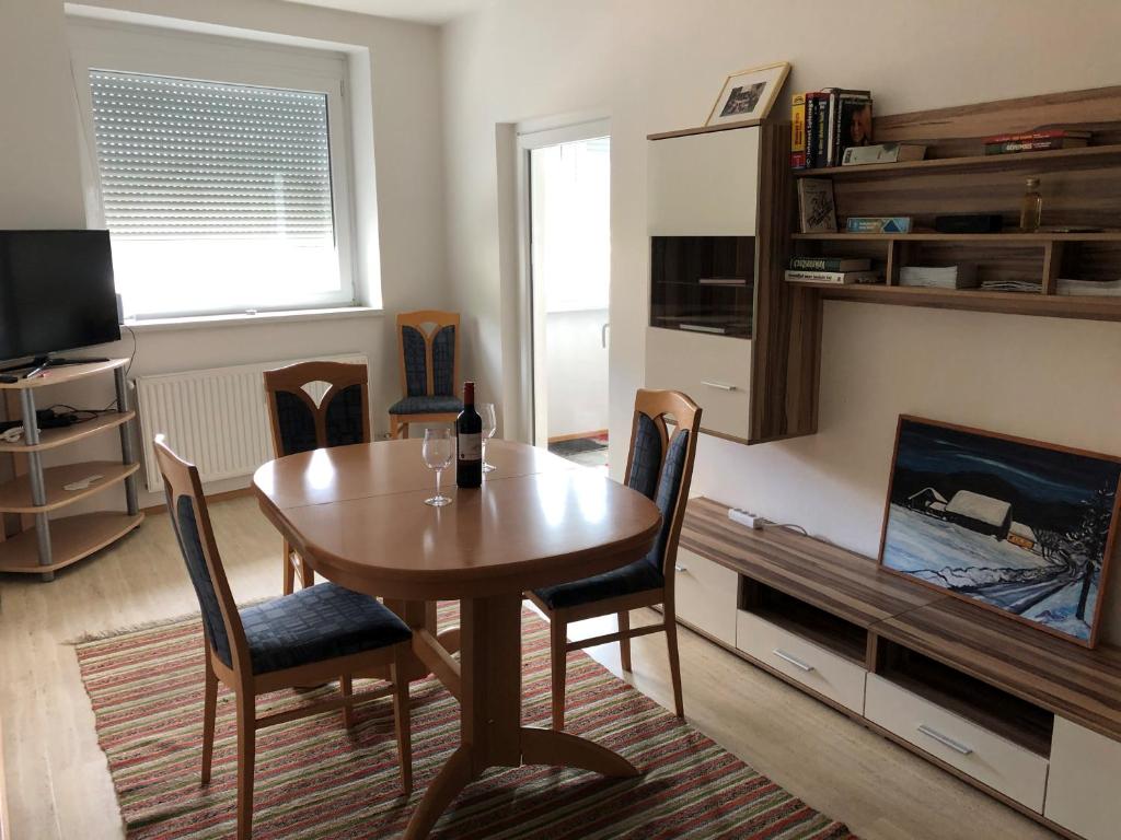 een woonkamer met een tafel en stoelen en een televisie bij City Apartment Railway in Klagenfurt