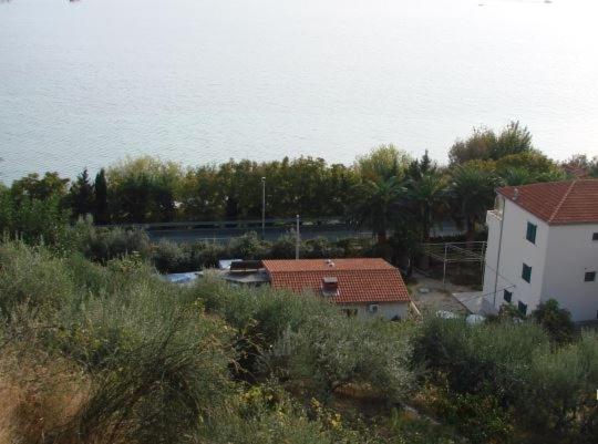 a view of a house and the water with trees at Apartment in Duce with sea view, loggia, air conditioning, Wi-Fi (4166-7) in Duće