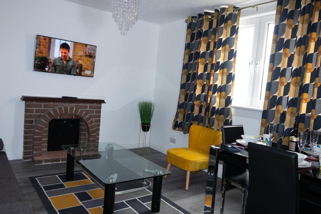 sala de estar con chimenea, mesa y sillas en Vion Apartment - Farquhar en Aberdeen