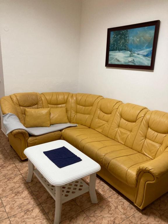sala de estar con sofá amarillo y mesa en Apartmanový byt v priemyselnej zóne, en Vranov nad Topľou
