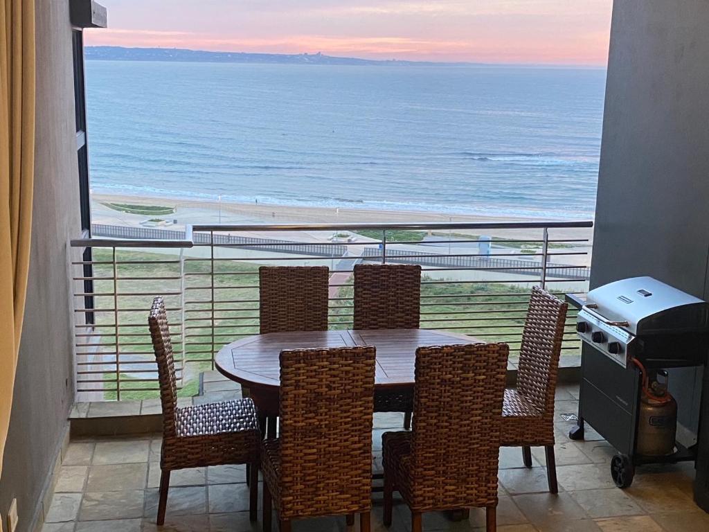 a table and chairs with a view of the ocean at Quayside 1001 Durban Point in Durban