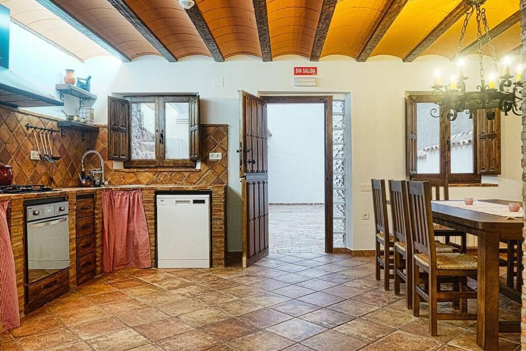 a kitchen with a table and a dining room at CASA RURAL EL TRANCO DEL LOBO in Casas de Ves