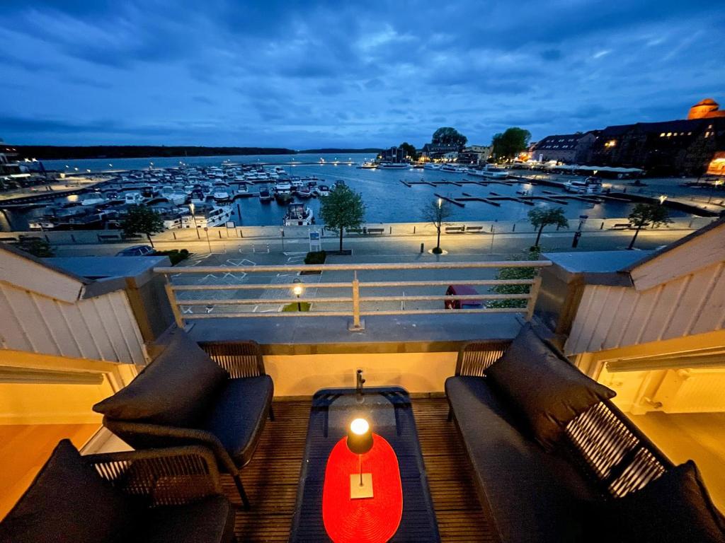 a balcony with chairs and a view of a harbor at loft müritzblick in Waren