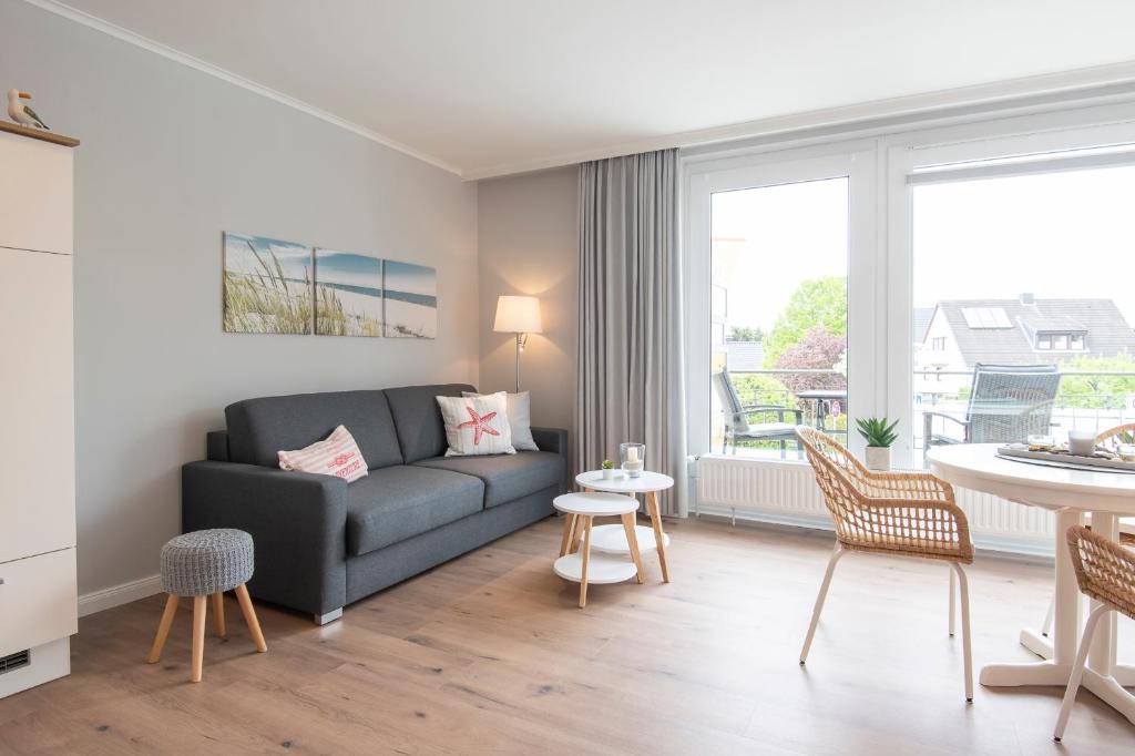 ein Wohnzimmer mit einem Sofa und einem Tisch in der Unterkunft Haus Panorama Wohnung 16, Steinmatz in Grömitz
