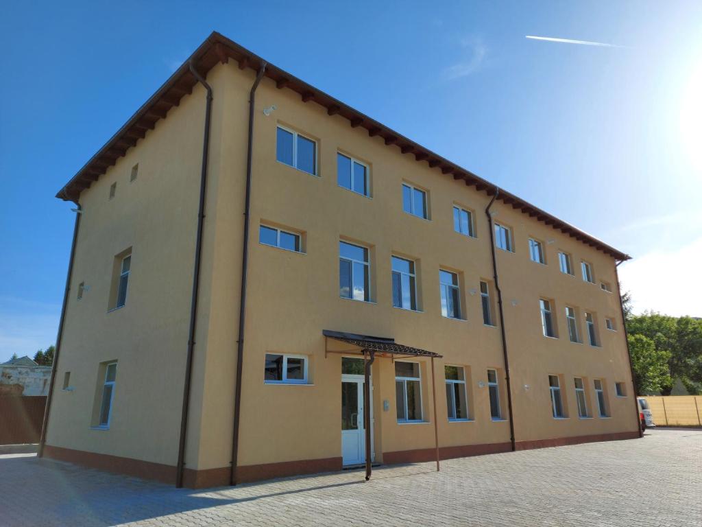 a large yellow building with a lot of windows at Apartamente Livada in Râmnicu Vâlcea