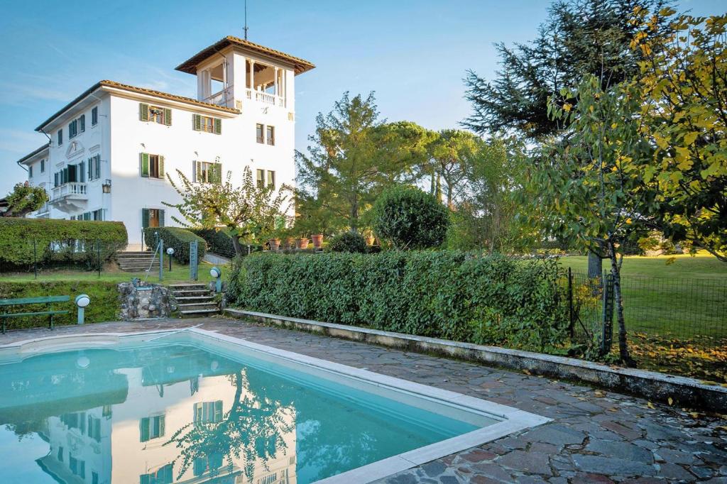 une maison avec une piscine en face d'un bâtiment dans l'établissement Villa Cerbaiola, Empoli, à Empoli