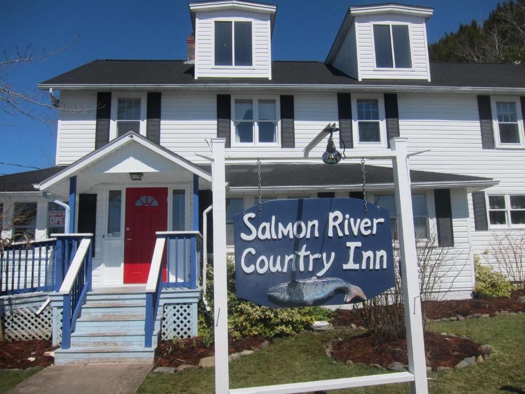 une maison avec un panneau indiquant une auberge de campagne sur la rivière du saumon dans l'établissement Salmon River Country Inn, à Head of Jeddore