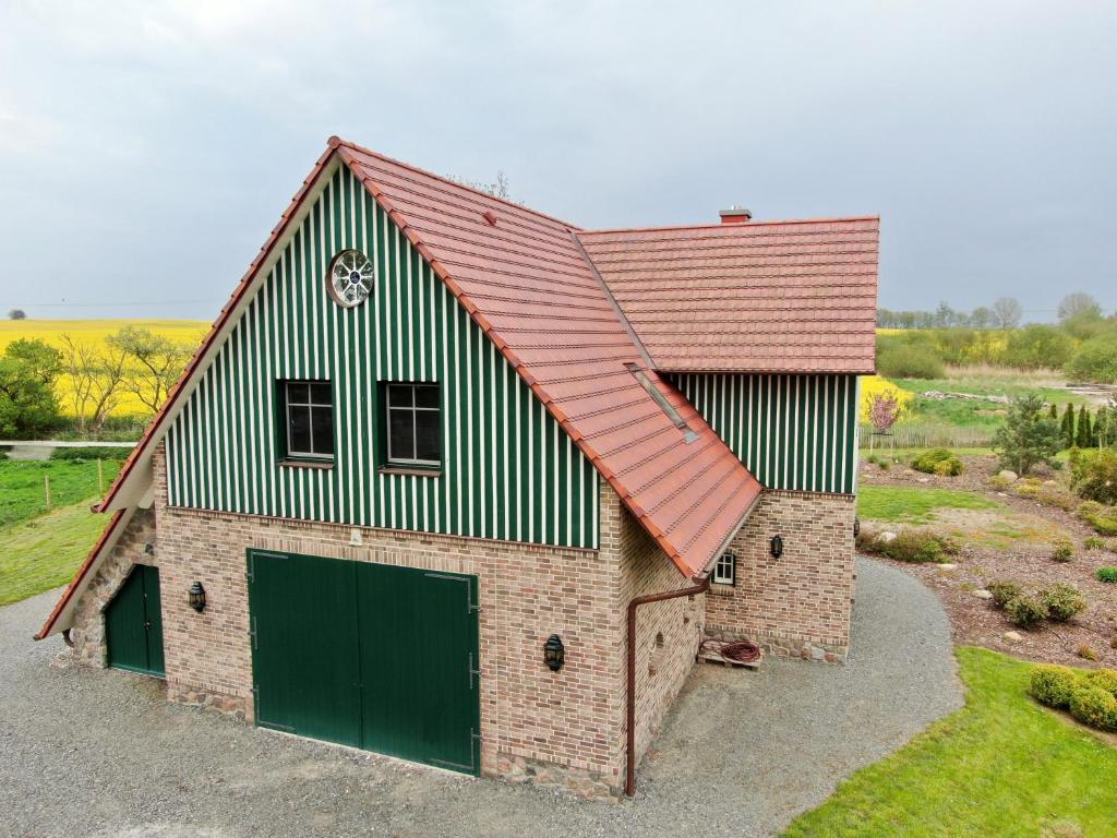 a barn with a red roof and a green garage at Ferienwohnung im Bootshaus in Putbus