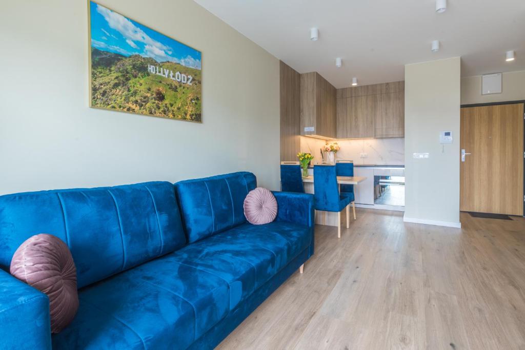 um sofá azul numa sala de estar com uma cozinha em HollyŁódź Apartment NETFLIX em Lódź