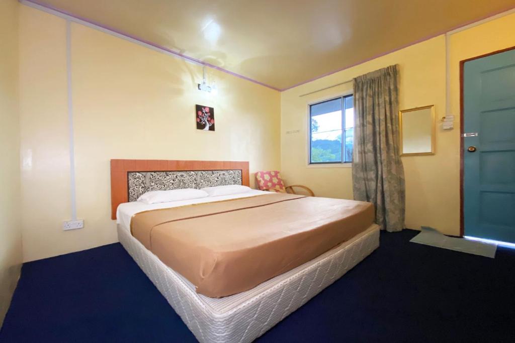 una camera con un grande letto e una finestra di OYO HOME 90285 Pogimpaan Homestay a Ranau