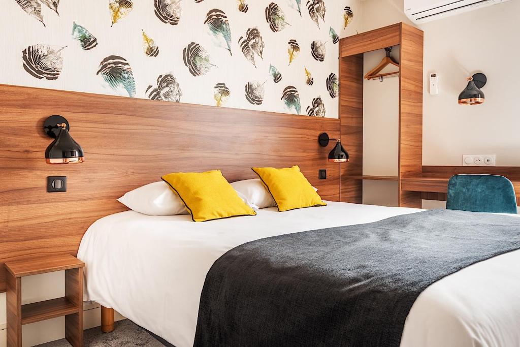 1 dormitorio con 1 cama blanca grande con almohadas amarillas en Contact Hôtel Astréa Nevers Nord et son restaurant la Nouvelle Table en Varennes Vauzelles