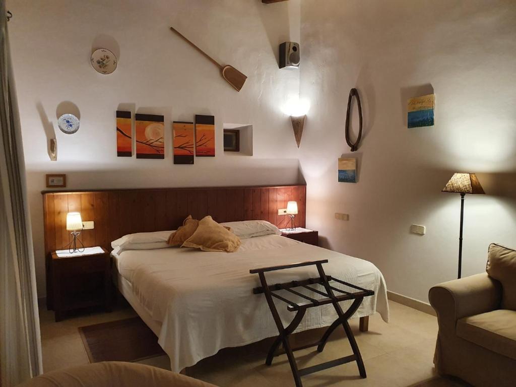 a bedroom with a bed with a table and a couch at Agroturisme Na Martina in Portopetro