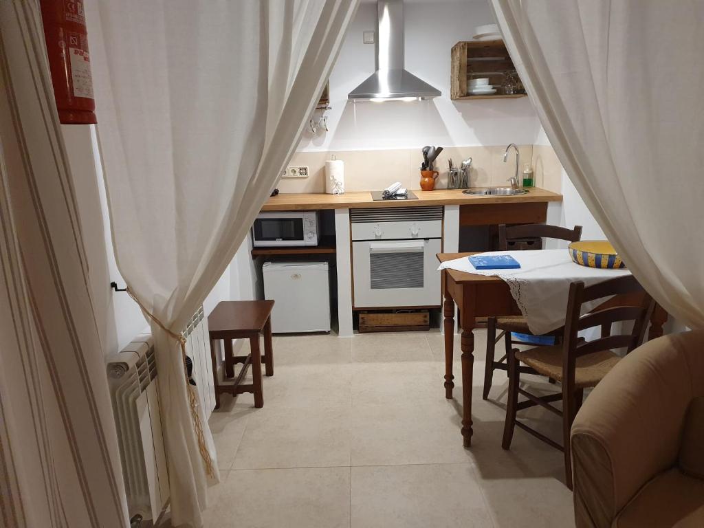 a kitchen with a table and a dining room at Agroturisme Na Martina in Portopetro