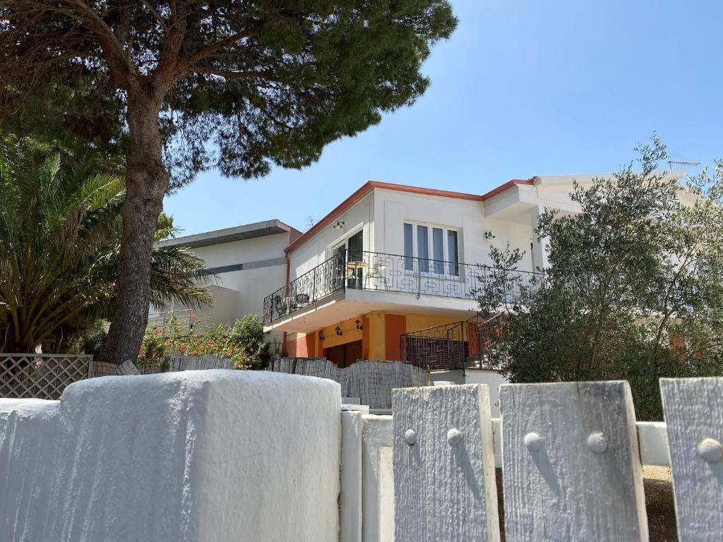 una recinzione bianca di fronte a una casa di Sabrina Apartments a Porto Pino