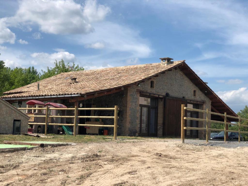 a barn with a fence in front of it at Mas El Conier in Taradell