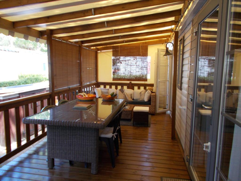 een kamer met een tafel en een bank op een balkon bij mobilhome charme funpass et wifi inclus in Gastes