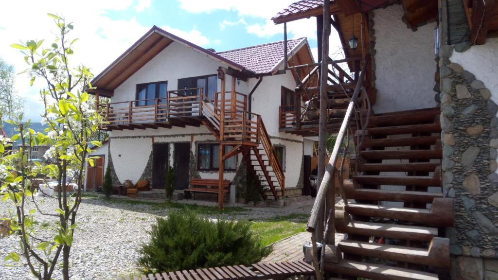 een huis met een houten trap daarheen bij Апартаменти "У Кузьмича" 2 in Mykulychyn