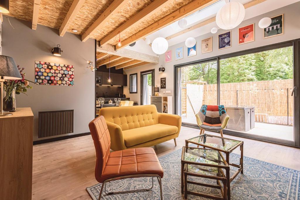 a living room with a couch and a chair at Gîtes Sérénaé avec vue sur rivière in Val de Vesle