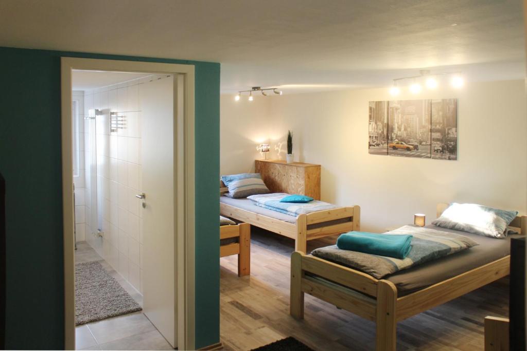 a room with two beds and a door to a bedroom at Gästehaus Silvia in Freigericht