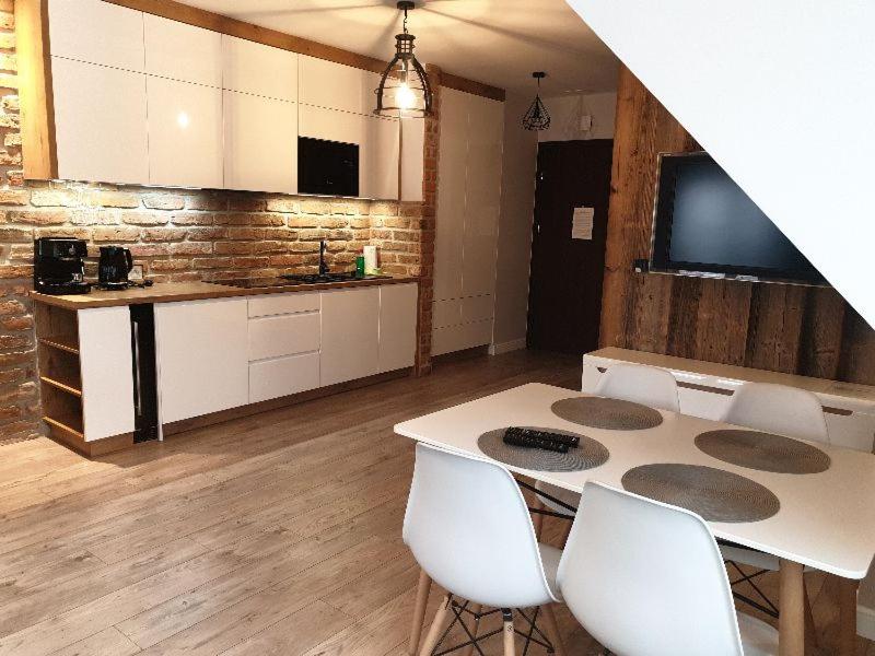 cocina con mesa blanca y sillas blancas en Apartament Triventi Karpacz en Karpacz