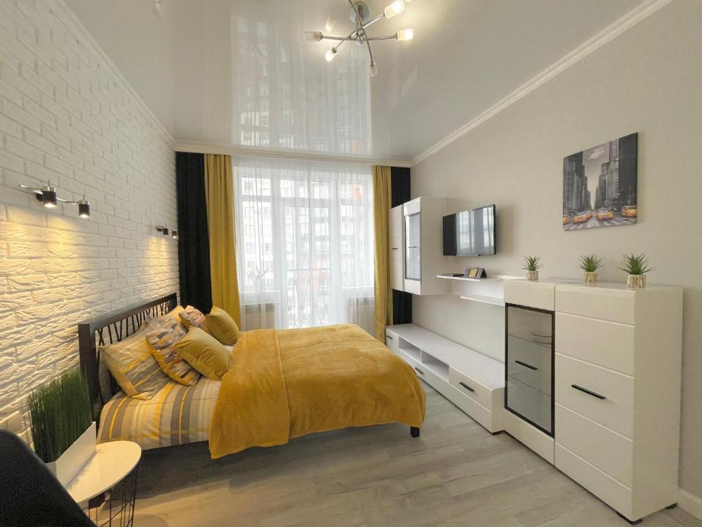 ein Schlafzimmer mit einem Bett mit einer gelben Decke in der Unterkunft Apartment Studio New York 45 in Irpin