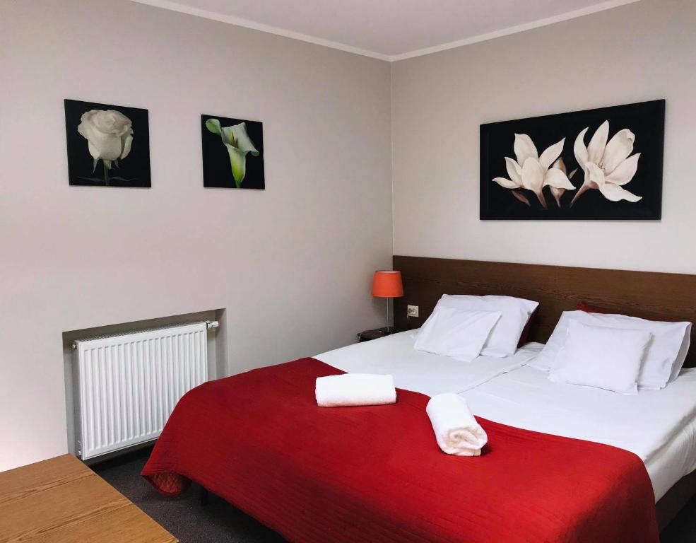 a bedroom with a large bed with a red blanket at Astral in Raszyn