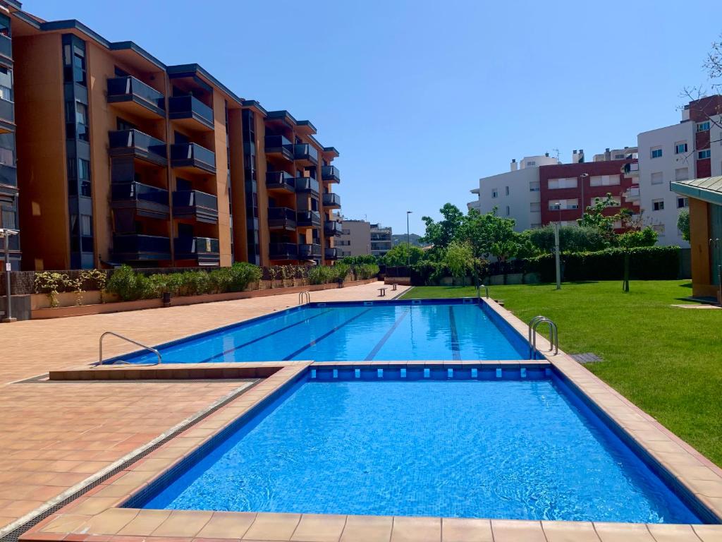a large swimming pool in front of a building at Apartment Santa Cristina in Lloret de Mar