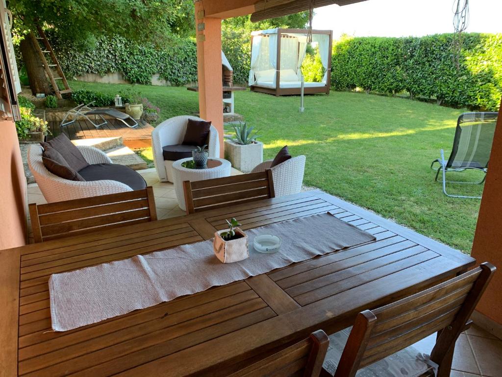 patio con mesa de madera y sillas en Apartment Ines, en Bale