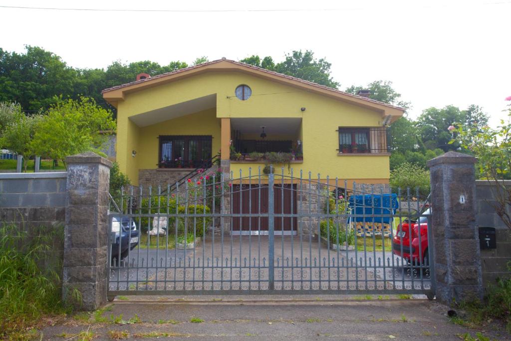 una casa amarilla con una puerta delante de ella en Villa Teresa con Aparcamiento y Wifi Incluido - Cangas De Onis, en Cangas de Onís