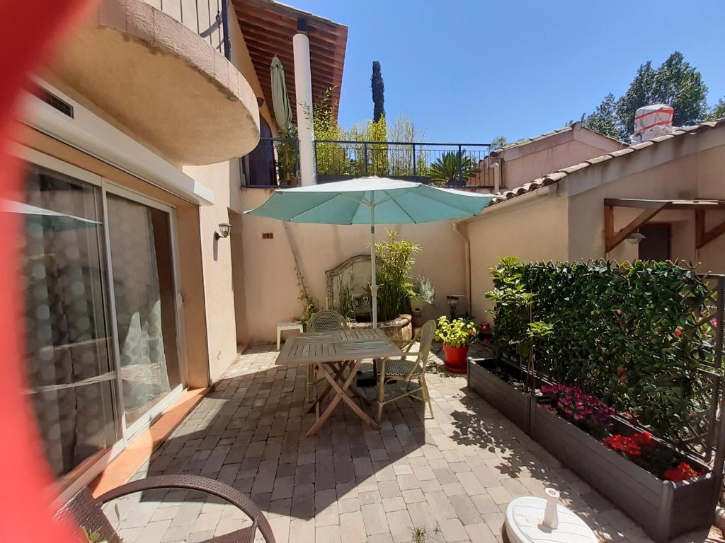 une terrasse avec une table et un parasol dans l'établissement Appartement Croisette, à Sainte-Maxime