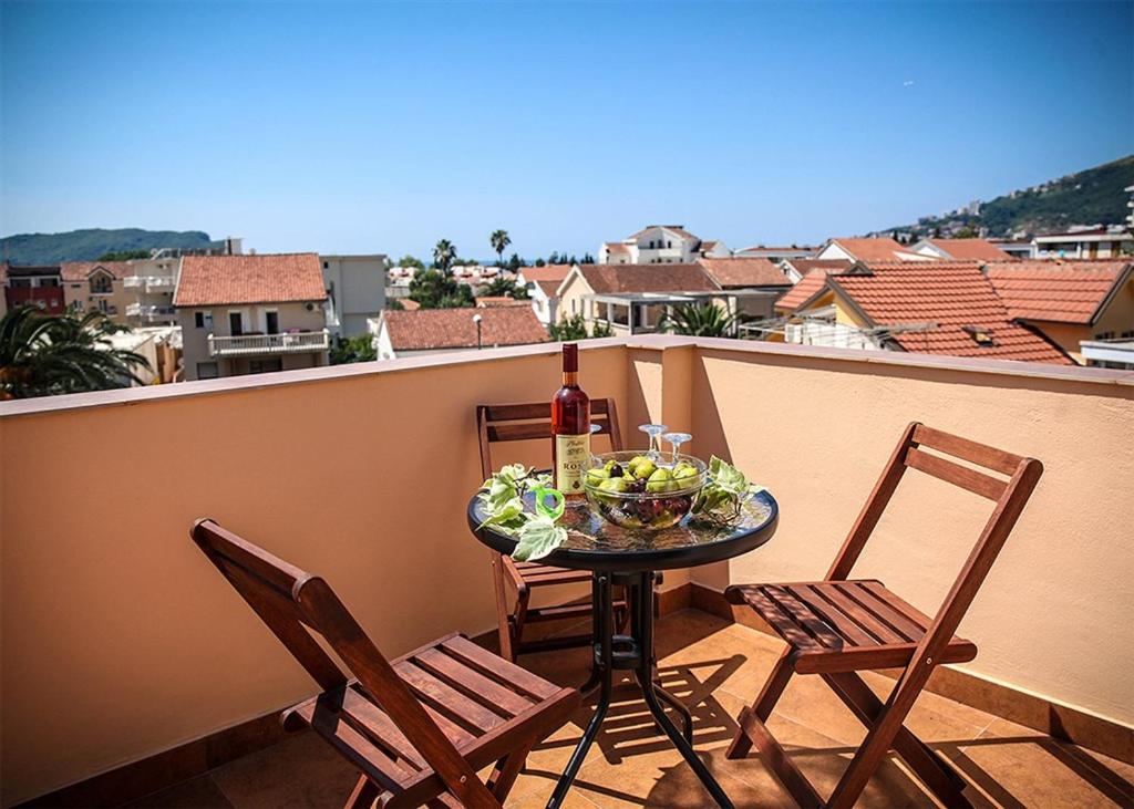 - une table avec une bouteille de vin et 2 chaises sur un balcon dans l'établissement Apartments Stari Ribar, à Budva