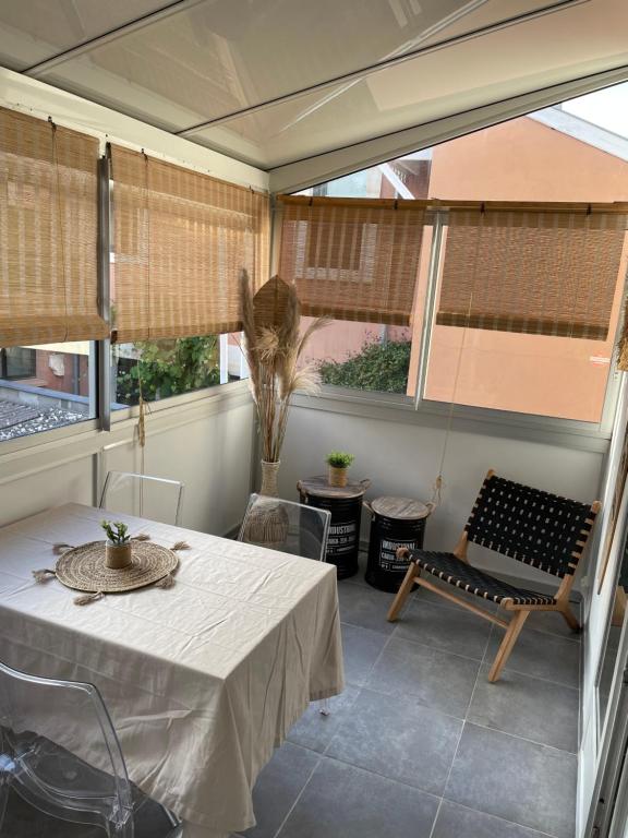 a room with a table and a chair and windows at Appartement Arcachon en hyper centre in Arcachon