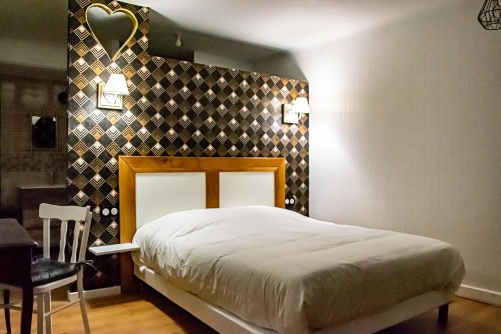 a bedroom with a bed and a table and a chair at Maison plume in Saint-Thiébault