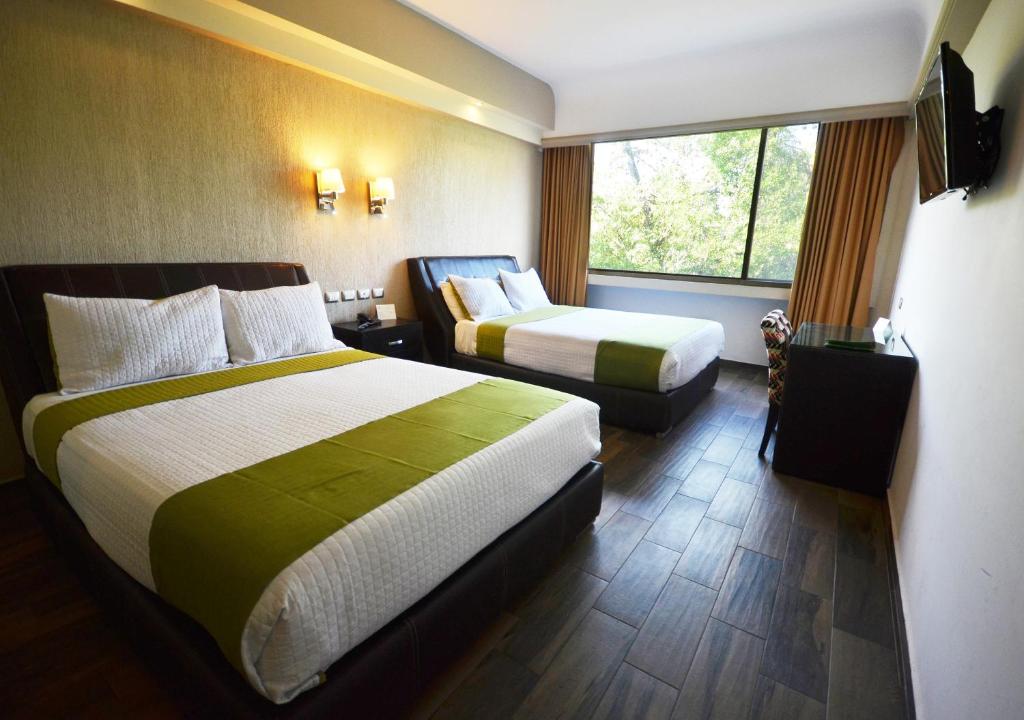 Una habitación de hotel con dos camas y una ventana. en Hotel Diana del Bosque by DOT Urban, en Morelia