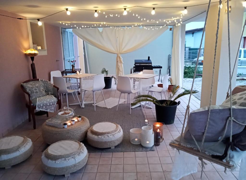 un patio con mesa, sillas y piano en B&B Tra mare e montagna - sauna e piscina, en San Giorgio di Pesaro