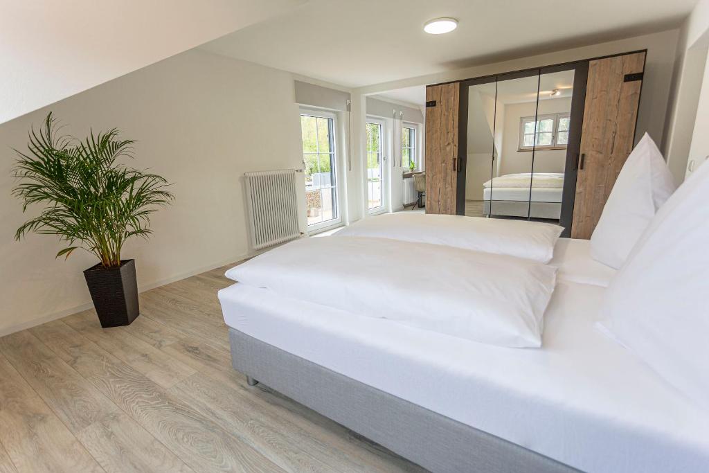 1 dormitorio con cama blanca y maceta en Pension Talblick, en Sulz am Neckar