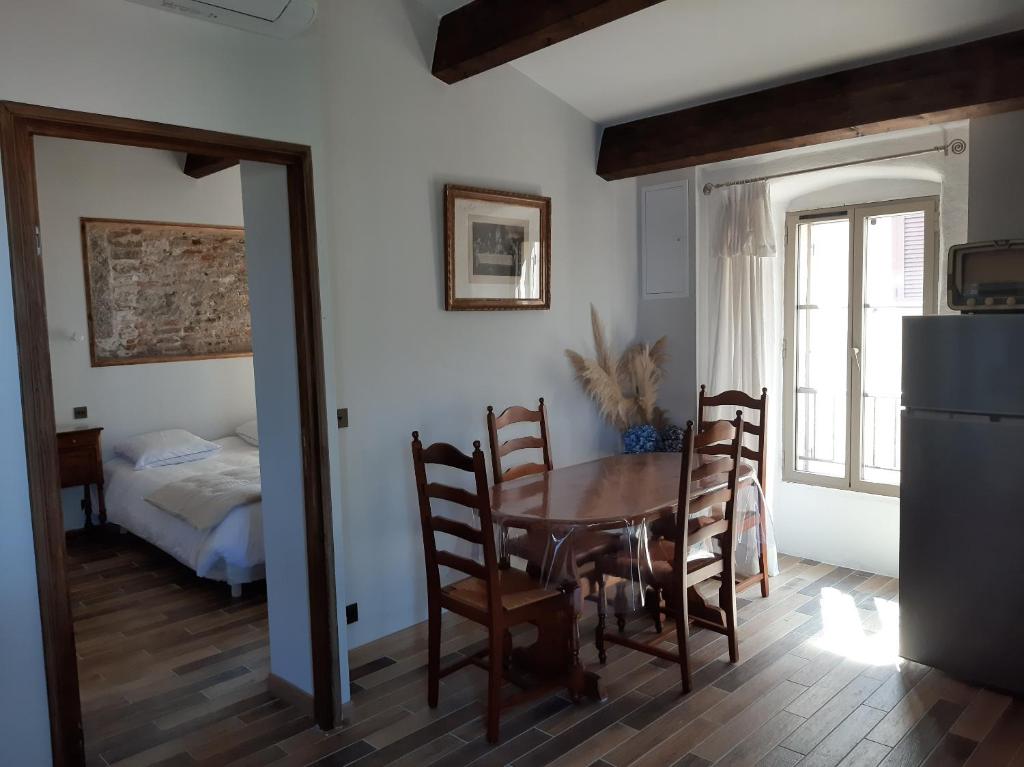 a dining room with a table and chairs and a bed at Casa Santa in Calvi