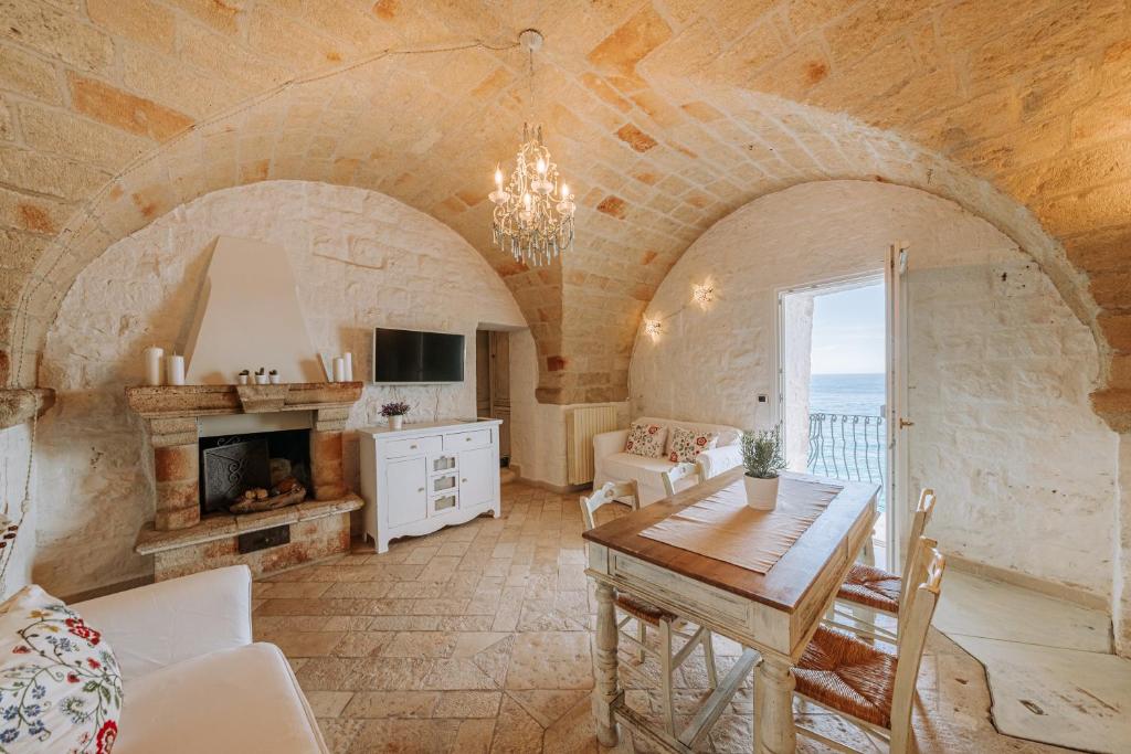 a living room with a table and a fireplace at Tre Archi Suite & Relais in Polignano a Mare