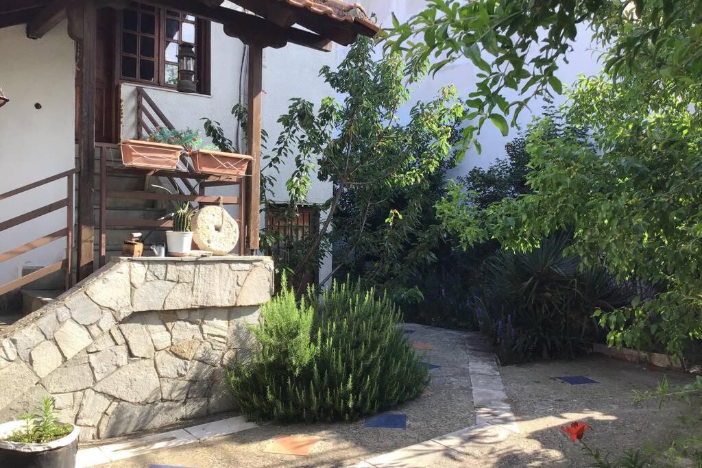 a house with a stone wall and a window at john actors home in Kavala